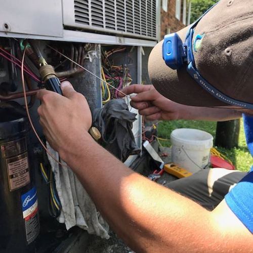 Repair Man RMB Solutions technician performing mobile HVAC maintenance and repair on a commercial unit.